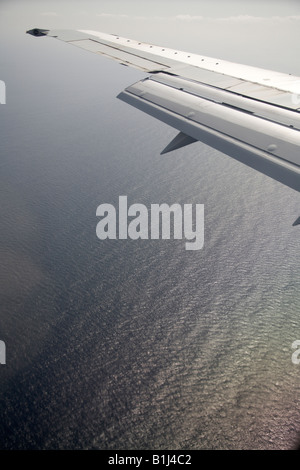 Elevato livello obliquo di vista aerea di ala di aeromobili battenti sopra il livello del mare Foto Stock