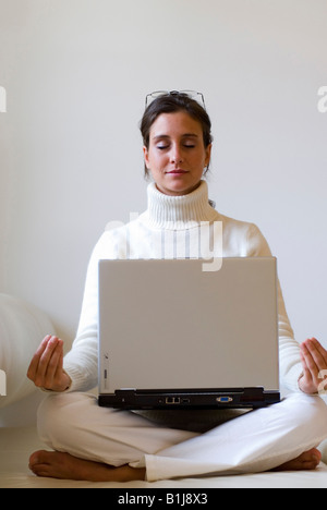 Giovane donna pratica dello yoga con un notebook sul suo giro Foto Stock