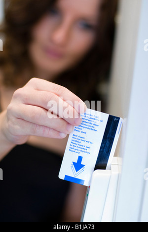 Giovane bella donna con capelli castani, apertura camera di albergo con chip card Foto Stock