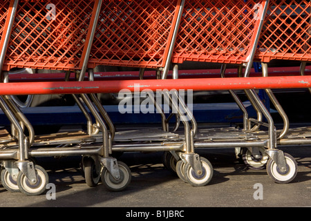 Negozio di generi alimentari carrelli parcheggiati davanti a un negozio di vendita al dettaglio che simboleggia lo shopping e la spesa Foto Stock