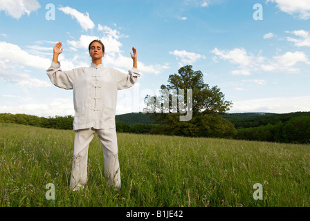 Giovane donna praticare il Tai Chi, Sau Gong esercizio, raccogliendo il Qi Foto Stock