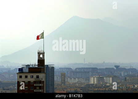 La bandiera italiana, il Tricolore, vola sulla cima di uno degli edifici più alti di Torino, Piemonte, Italia. Foto Stock