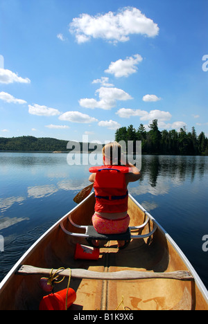 Giovane ragazza in canoa kayak su un pittoresco lago Foto Stock