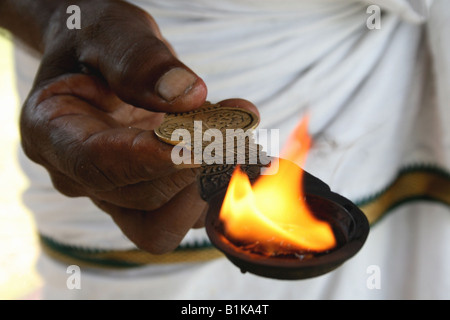 Close-up di piccoli arti fire diva nella mano di un sacerdote Indù , India Foto Stock