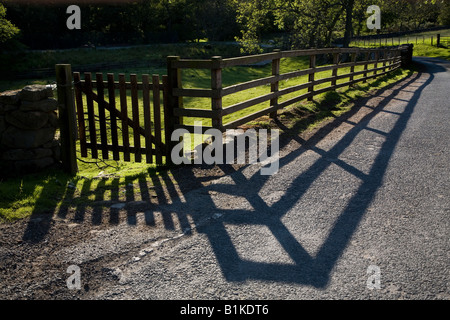 Sera La luce del sole proietta ombre di un cancello un recinto in un vicolo del paese North Yorkshire England Regno Unito Foto Stock