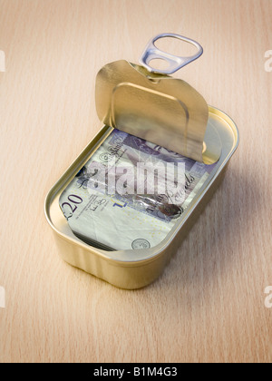 Anello di sicurezza a strappo stagno contenente £20 note sulla superficie di legno Foto Stock