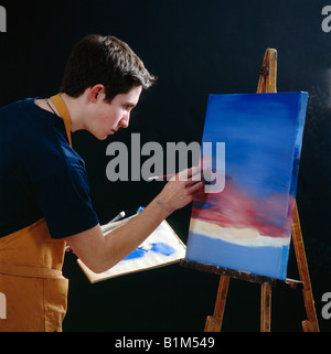 Alta scuola di pittura boy una tela su un cavalletto in classe d'arte Foto Stock