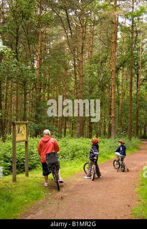 Famiglia in cerca di fauna selvatica di Bosco segno a Center Parcs a Elveden vicino a Thetford, Regno Unito Foto Stock