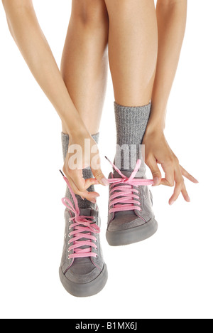 Le gambe della donna nello sport stivali e mani lacci di fissaggio Foto Stock