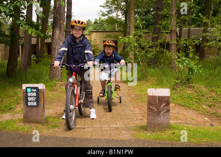 I ragazzi al di fuori Villa sulla bici a Center Parcs a Elveden vicino a Thetford, Regno Unito Foto Stock