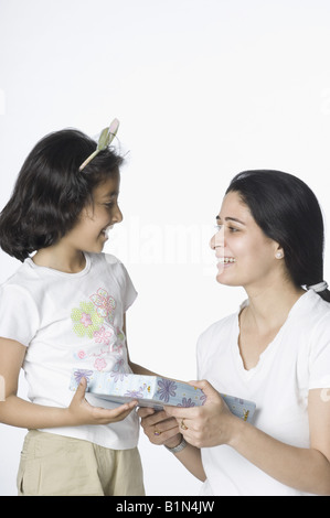 Metà donna adulta dando un regalo per sua figlia Foto Stock