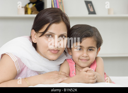 Ritratto di una metà donna adulta con sua figlia giacente sul letto Foto Stock