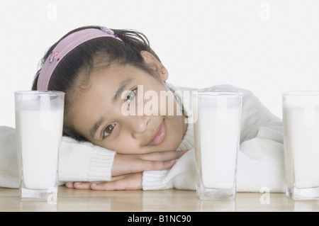 Ritratto di una ragazza con bicchieri di latte su un tavolo Foto Stock