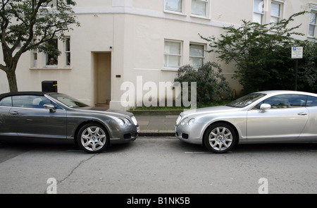 Due Bentley auto di lusso parcheggiato il naso a naso in costosi London street Foto Stock