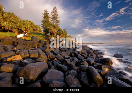 Acqua schiantarsi su promontorio roccioso di sunrise Foto Stock