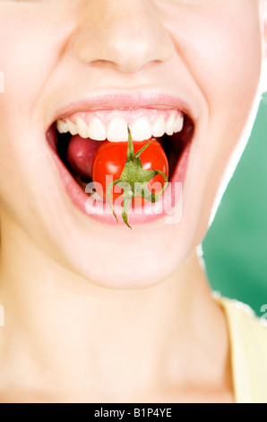 Donna di mangiare pomodoro ciliegino Foto Stock