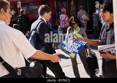 Un uomo di consegnare una rivista a Londra Foto Stock