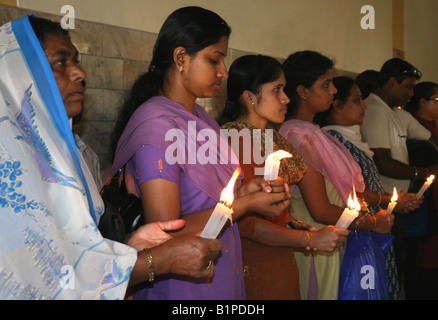 Cattolica le donne indiane Tenere candele e il culto a Gesù Bambino la Chiesa Cattolica , Bangalore , India Foto Stock