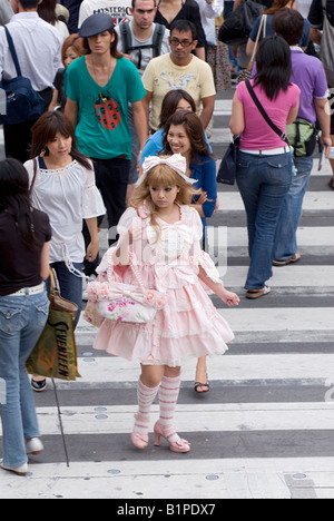 Ragazza vestita in frilly lolita stile fashion camminare su una trafficata strada di Tokyo nel quartiere alla moda di Aoyama Omotesando district Foto Stock