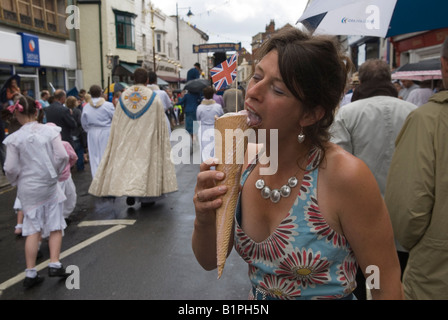 Cono gelato con la bandiera Union Jack giovane donna che mangia guardando la sfilata annuale del Whitstable Oyster Festival Whitstable Kent 2000s 2007 UK HOMER SYKES Foto Stock