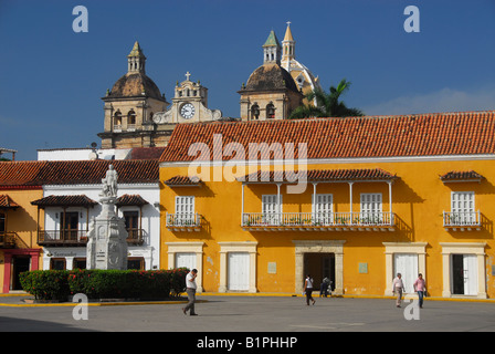 Statua di Cristoforo Colombo nella Plaza de la Aduana con la Chiesa di San Pietro torri in background, Cartagena de Indias Foto Stock