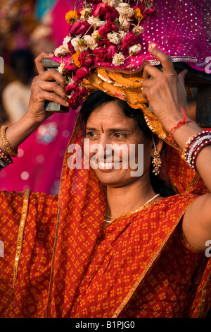 Donna di Rajasthani porta effigi di Shiva e Parvati presso il festival di GANGUR o MEWAR FESTIVAL in Udaipur Rajasthan in India Foto Stock