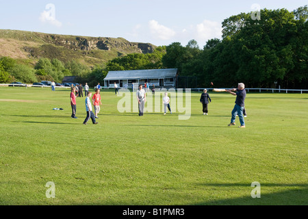 I ragazzi giocare a cricket su un territorio rurale campo da cricket Foto Stock