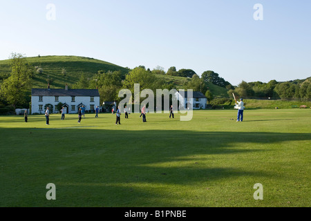 I ragazzi giocare a cricket su un territorio rurale campo da cricket Foto Stock