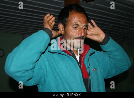 Un musulmano del Kashmir esegue Salat preghiera posizione takbir ( o ) Qiyam inizio della preghiera in una moschea , Gulmarg , Kashmir , India Foto Stock