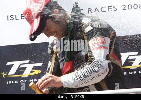 Australian Cameron Donald godendo il bagno di champagne dai suoi compagni concorrenti dopo il Senior TT garlanding cerimonia. Foto Stock