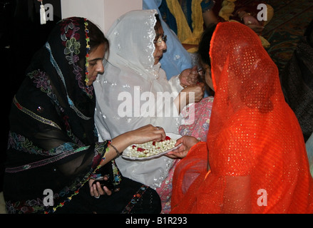 Donna musulmana distribuisce fiori presso una casa in occasione di Moulid al Nabi profeti ( PBSL ) compleanno , India Foto Stock