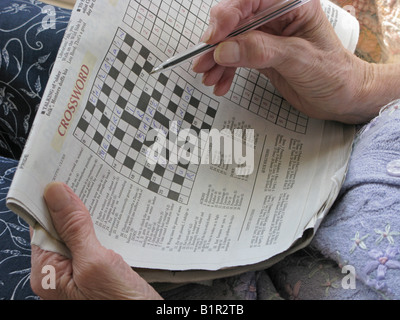 Donna anziana facendo un cruciverba usando il suo cervello per mantenerlo attivo Foto Stock