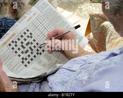 Donna anziana facendo un cruciverba usando il suo cervello per mantenerlo attivo Foto Stock