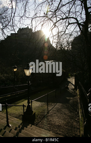 Città di Edimburgo in Scozia. Stagliano sunrise del Castello di Edimburgo sulla Castle Rock visto attraverso i rami degli alberi. Foto Stock
