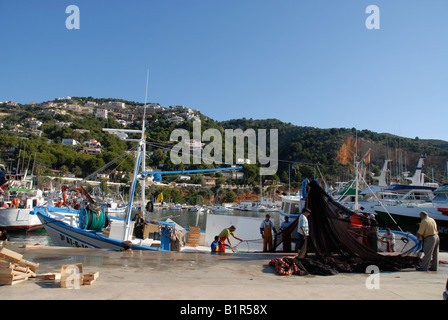 Pescatori tendono reti da pesca in barca nel porto, Javea / Xabia, Provincia di Alicante, Comunidad Valenciana, Spagna Foto Stock