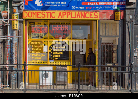 Un fatiscente negozio di vendita di merci bianco su Dalston Lane, nella parte interna della città Borough of Hackney Londra Foto Stock