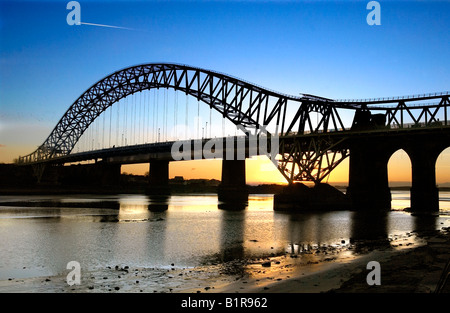 La stazione di Queensway Giubileo ponte che attraversa il fiume Mersey visto dalla banca di Widnes guardando verso Runcorn al tramonto in febbraio Foto Stock