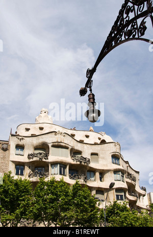 La facciata della Casa Milà, conosciuta anche come La Pedrera o cava, progettato dall'architetto Antoni Gaudí, sotto una lampada di strada de Foto Stock