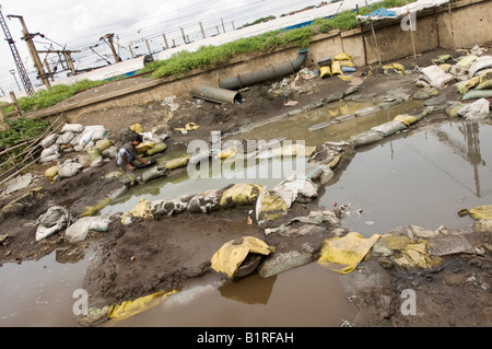 Indian day operaio tramite smistamento schegge di rame da tossici scorie industriali, guadagnandosi da vivere con il riciclaggio dei rifiuti in slu Foto Stock