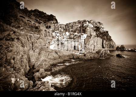 Immagine seppia del villaggio di Manarola arroccata su ripide scogliere lungo la costa della Liguria Cinque Terre, Italia, Europa Foto Stock