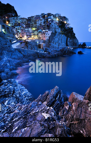 Villaggio di Manarola arroccata su coste scoscese al crepuscolo, la Liguria Cinque Terre, Italia, Europa Foto Stock