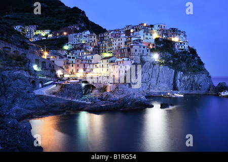 Villaggio di Manarola arroccata su coste scoscese al crepuscolo, la Liguria Cinque Terre, Italia, Europa Foto Stock