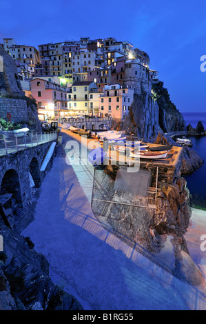 Villaggio di Manarola arroccata su coste scoscese al crepuscolo, la Liguria Cinque Terre, Italia, Europa Foto Stock