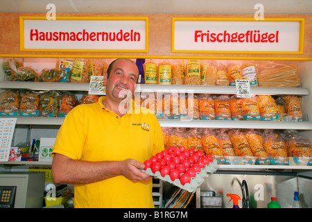 Fornitore di pollame tenendo un cartone di uova tinti, settimanale dell'agricoltore nel mercato Muehldorf am Inn, Alta Baviera, Germania, Europa Foto Stock