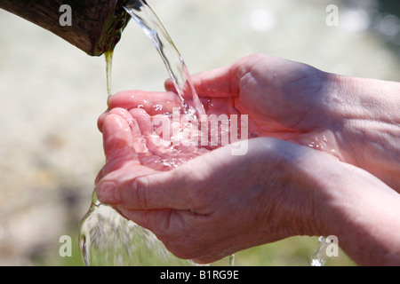 Mani acqua cupping, molla acqua da una fontana, Ramsau Chiesa, Reiteralpen Alpi vicino a Berchtesgaden, Alta Baviera, Germania, Foto Stock