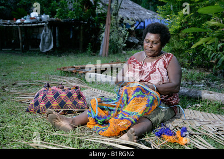 Donna di annodatura Bilum un sacco di stringa, Biliau, Papua Nuova Guinea, Melanesia Foto Stock