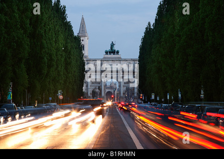Siegestor, Porta Vittoria, con sentieri di luce dal traffico in Leopoldstrasse Street, Monaco di Baviera, Baviera, Germania, Europa Foto Stock