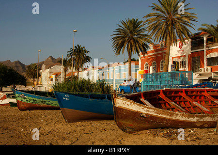 Imbarcazioni a remi tirato sulla spiaggia di fronte alla passeggiata costiera di Mindelo sull'isola di Sao Vicente, Isole di Capo Verde, Cape Ver Foto Stock