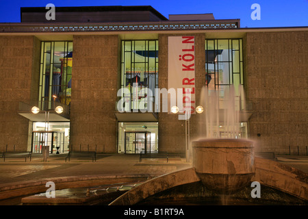 Il piazzale antistante e fontana di Oper Koeln, la Colonia Operahouse dal crepuscolo, Offenbachplatz, Offenbach Square, Colonia, Nord Rhine-We Foto Stock