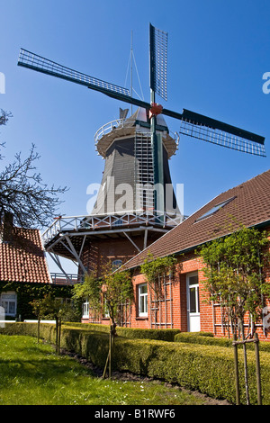 Il mulino a vento storico costruito in tipico stile olandese con il fiocco sul retro, mondatura mill, Esens, Frisia orientale, Bassa Sassonia, Foto Stock